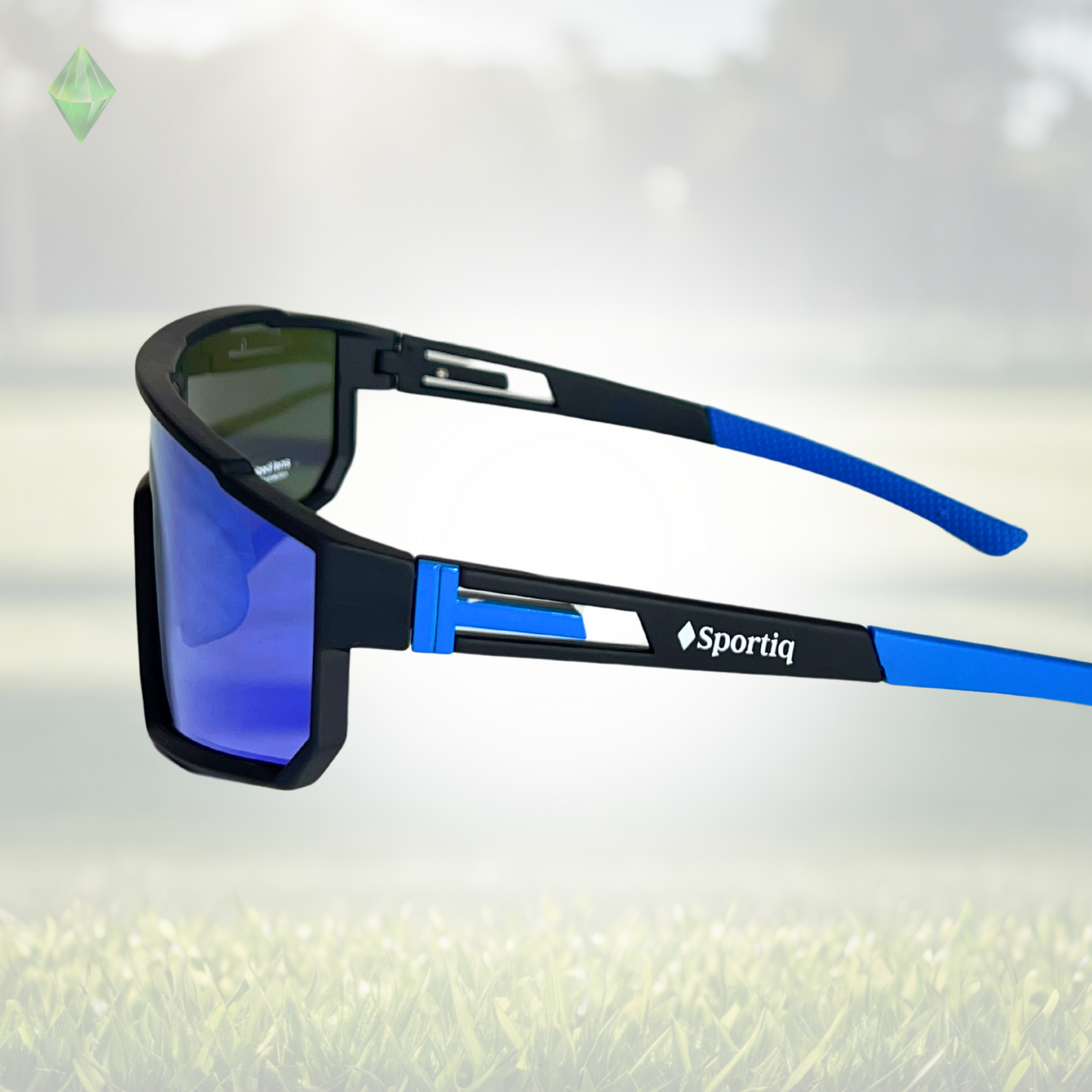 A pair of Sportiq VividShield sunglasses with blue reflective lenses and a black frame, polarized UV400, polycarbonate frame with TAC lens, displayed on a grass background.