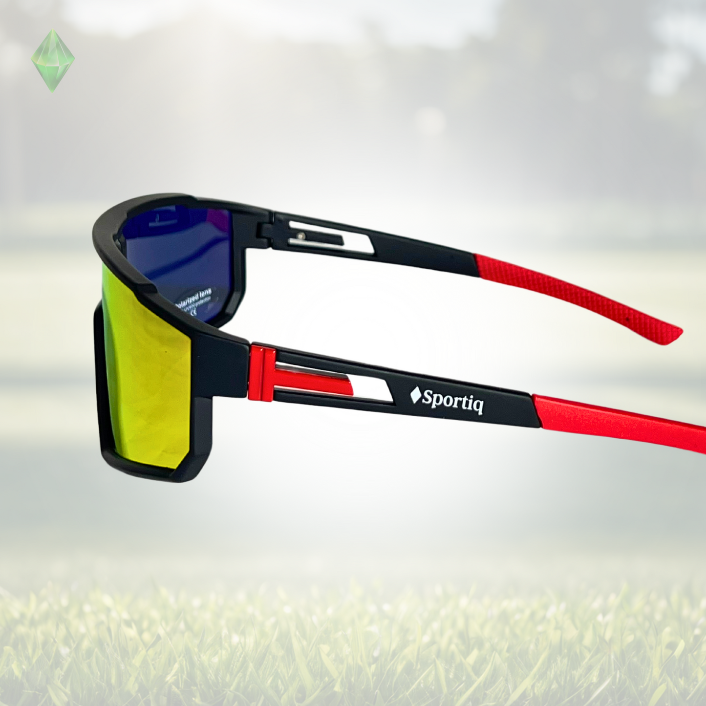 A pair of Sportiq VividShield sunglasses with black and red frame and red reflective lens, polarized UV400, polycarbonate frame with TAC lens, displayed on a grass background.