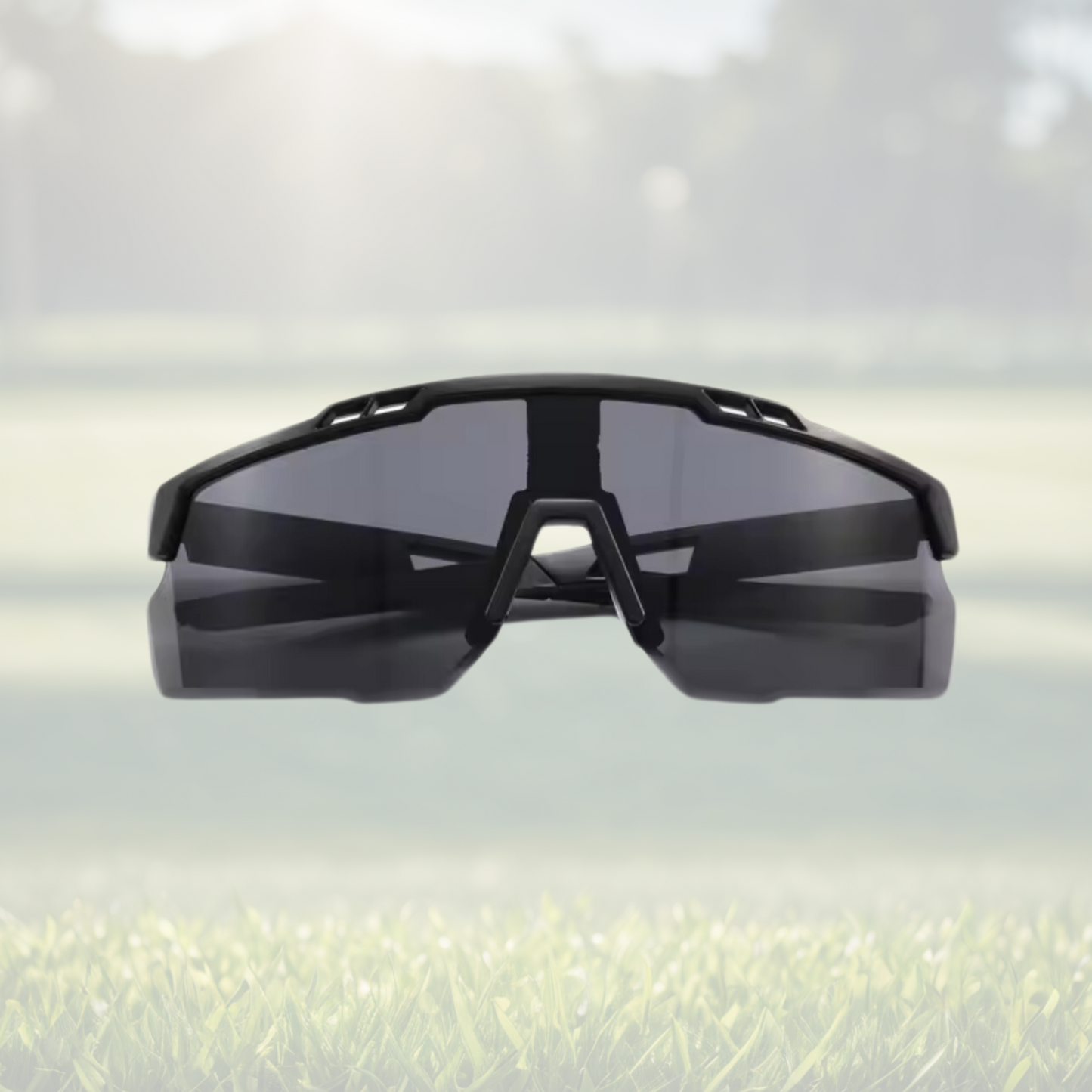 A pair of Sportiq Nimbus Onyx performance sunglasses with black lenses and black frame, UV400, polycarbonate frame with polycarbonate lens, displayed on a grass background.
