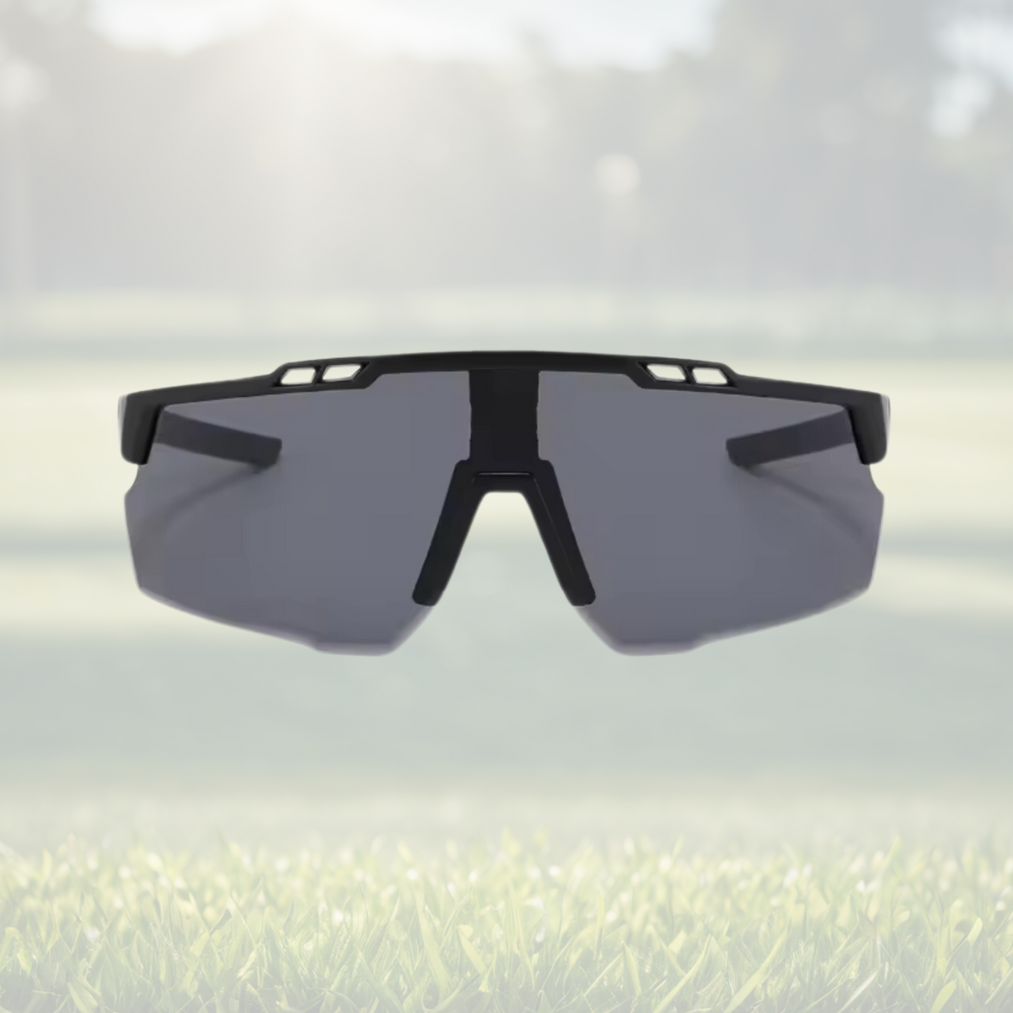A pair of Sportiq Nimbus Onyx performance sunglasses with black lenses and black frame, UV400, polycarbonate frame with polycarbonate lens, displayed on a grass background.