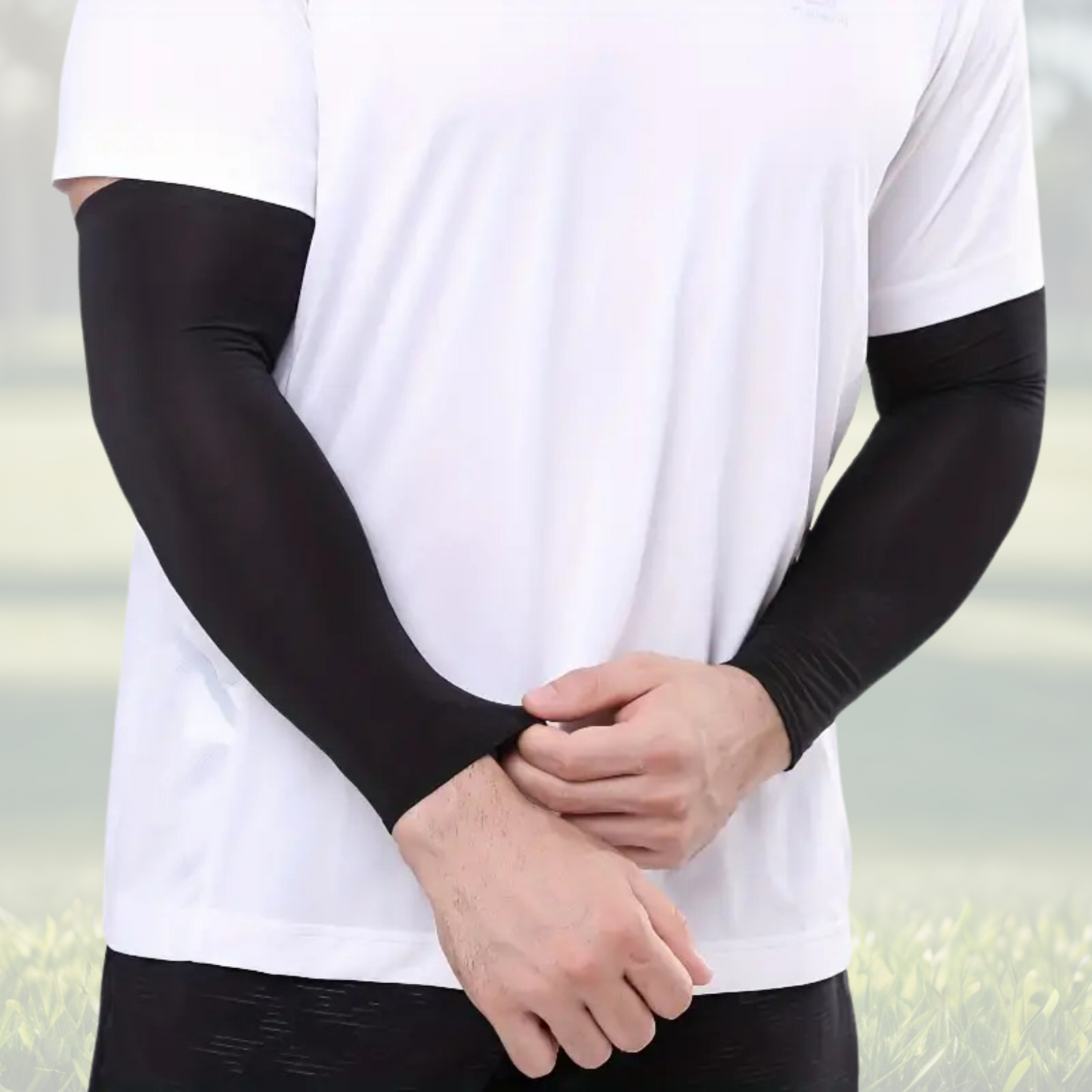 A pair of Sportiq Swift Sleeves in Stealthcore Black, flexible and stretchy made of breathable polyester with a cooling and sun blocking affect, displayed on a grass background.