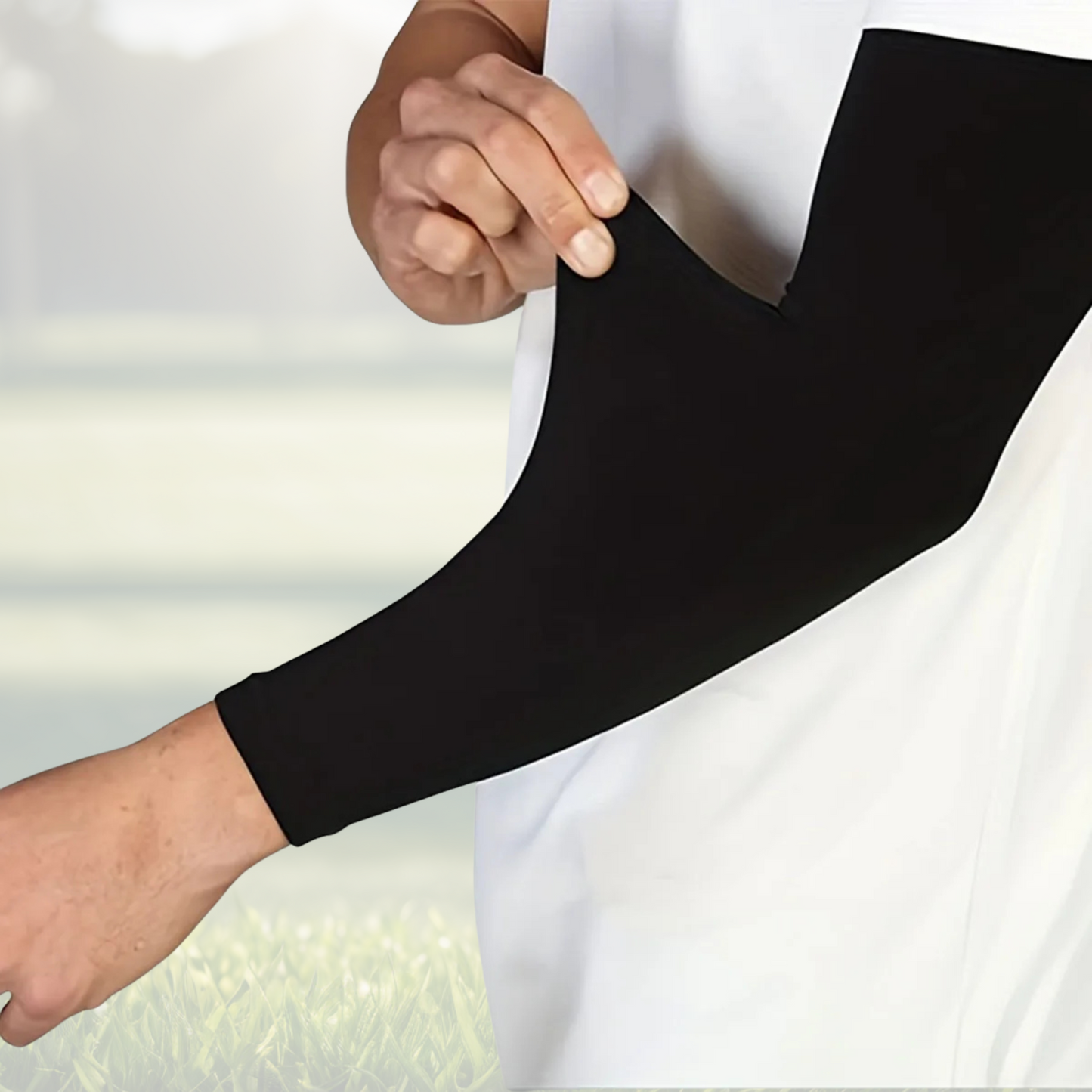 A pair of Sportiq Swift Sleeves in Stealthcore Black, flexible and stretchy made of breathable polyester with a cooling and sun blocking affect, displayed on a grass background.