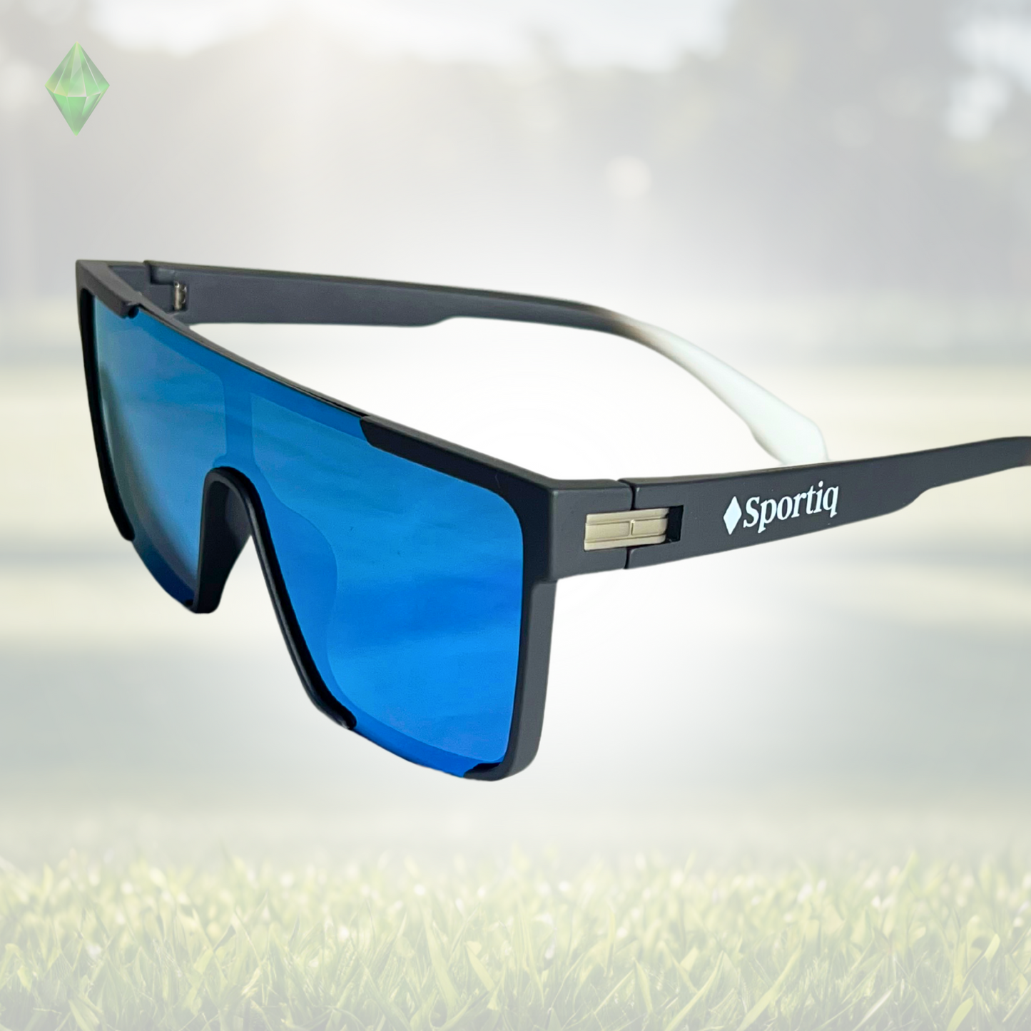 A pair of Sportiq Zen - Blue professional sport sunglasses with blue reflective lenses and black frame, polarized UV400, polycarbonate frame with TAC lens, displayed on a grass background.