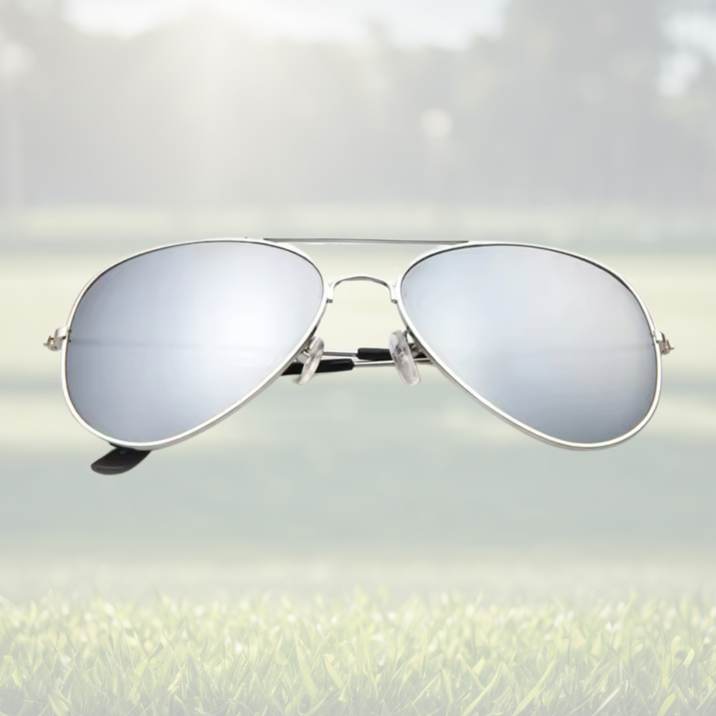A pair of Sportiq Altitude Glacier professional performance sunglasses with reflective silver lenses and steel frame, UV400 with polycarbonate lens, displayed on a grass background.