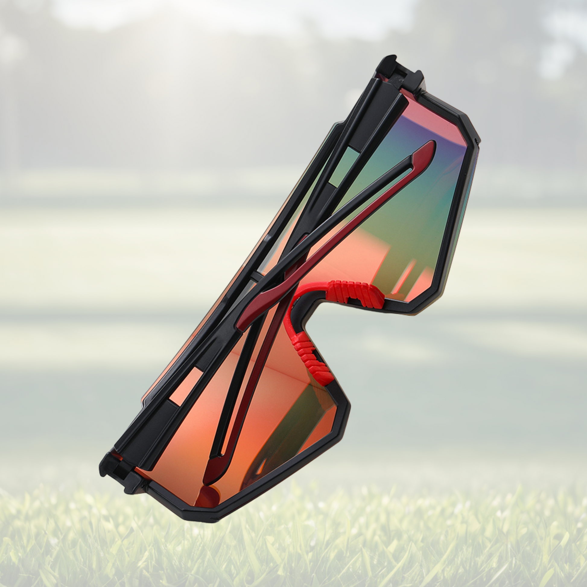 A pair of Sportiq Gamechanger Ember professional sport sunglasses with red reflective lenses and black frame, polarized UV400, polycarbonate frame with TAC lens, displayed on a grass background.