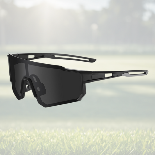 A pair of Sportiq Gamechanger Stealth professional sport sunglasses with black lenses and black frame, polarized UV400, polycarbonate frame with TAC lens, displayed on a grass background.