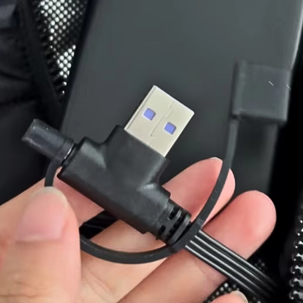 Battery connector for a Black Sportiq HeatCore Jacket, weatherproof with insulation and electric heated carbon fibre panels. 