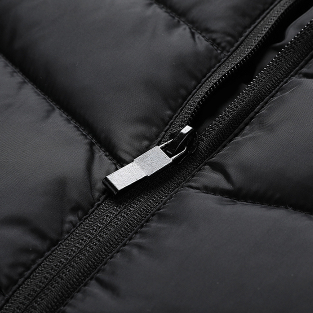 Showcase of the zip for a Black Sportiq HeatCore Vest, puffer style and weatherproof, wind resistant with electric heated carbon fibre panels. 