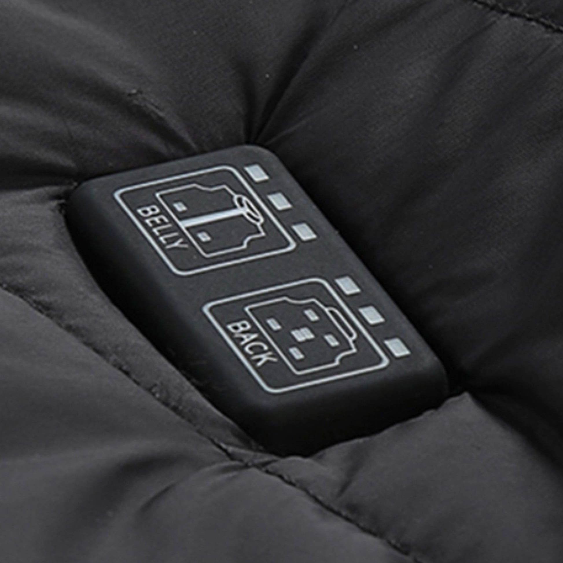 Showcase of a zone control button for a Black Sportiq HeatCore Vest, puffer style and weatherproof, wind resistant with electric heated carbon fibre panels. 