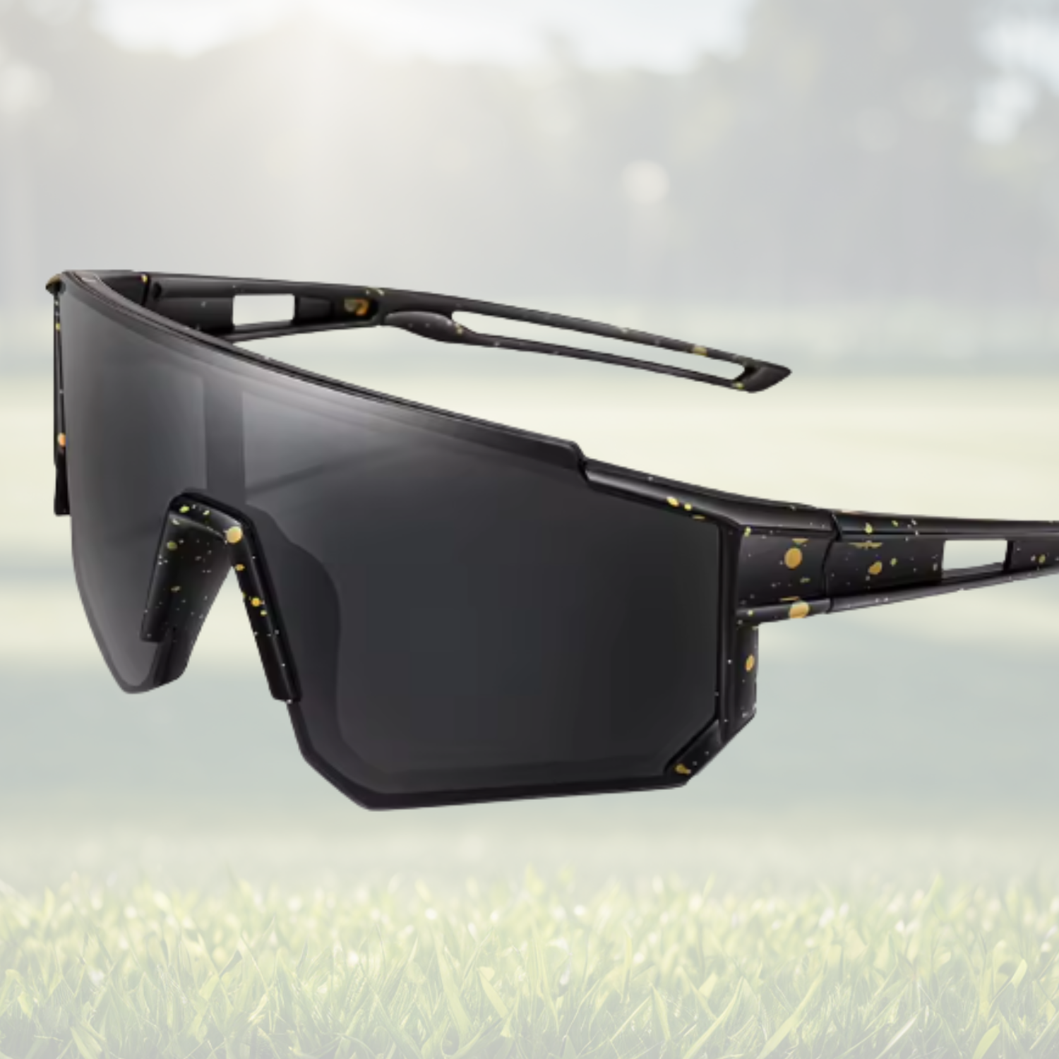 A pair of Sportiq JNR kids Jet Black sport sunglasses with black lenses and black frame, UV400, polycarbonate frame with polycarbonate lens, displayed on a grass background.