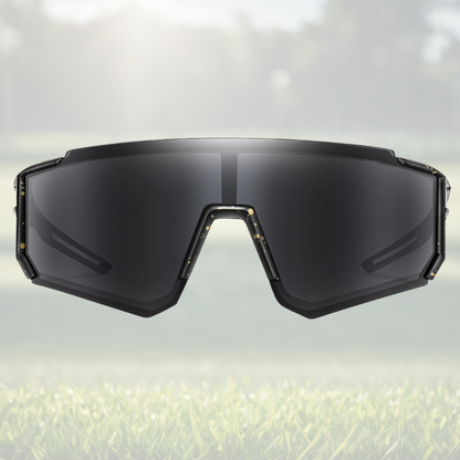 A pair of Sportiq JNR kids Jet Black sport sunglasses with black lenses and black frame, UV400, polycarbonate frame with polycarbonate lens, displayed on a grass background.