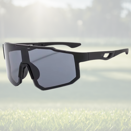 A pair of Sportiq Nimbus Onyx performance sunglasses with black lenses and black frame, UV400, polycarbonate frame with polycarbonate lens, displayed on a grass background.