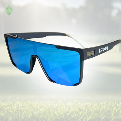A pair of Sportiq Zen - Blue professional sport sunglasses with blue reflective lenses and black frame, polarized UV400, polycarbonate frame with TAC lens, displayed on a grass background.